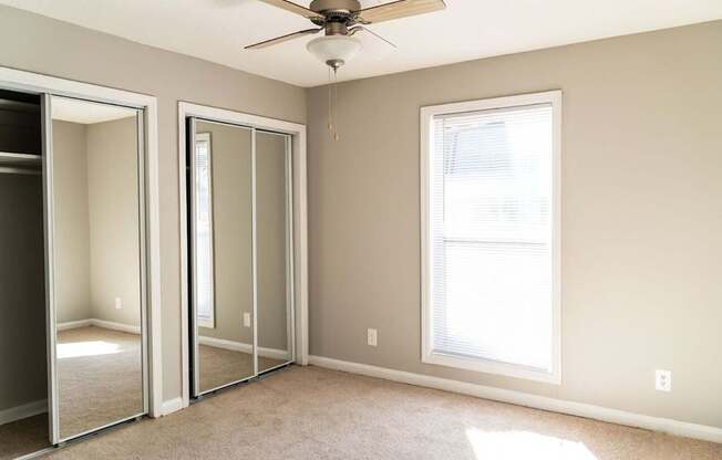 A room with a ceiling fan and a window.