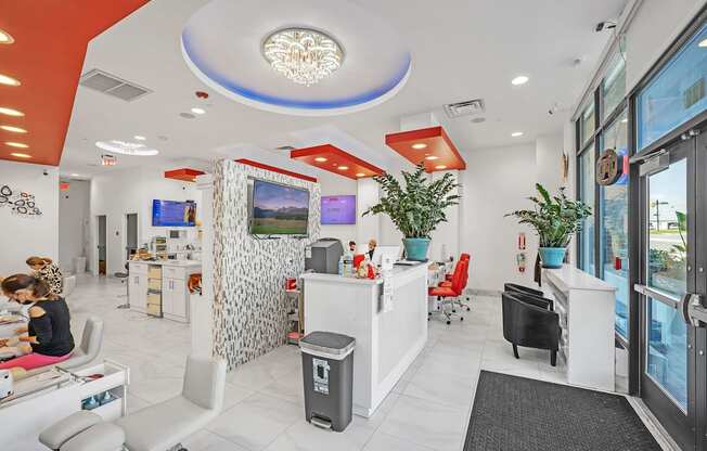 A woman is sitting at a desk in a brightly lit office space.