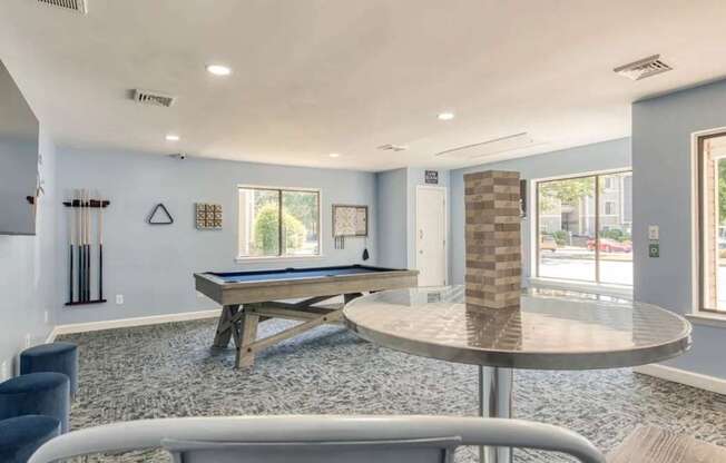 A room with a pool table and a television.