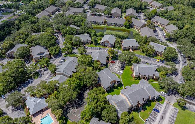 A bird's eye view of a residential area with houses and a swimming pool.