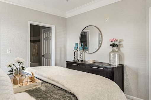 A bedroom with a large bed and a mirror above it.