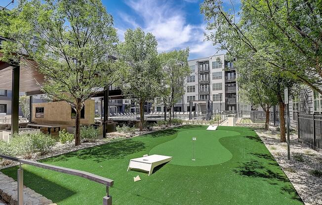 a putting green in a courtyard with a building in the background