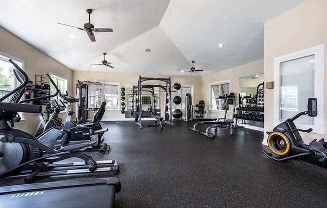 A spacious gym with a variety of equipment including treadmills, elliptical machines, and weights.