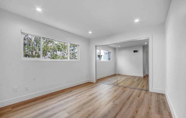 a living room with white walls and a large window