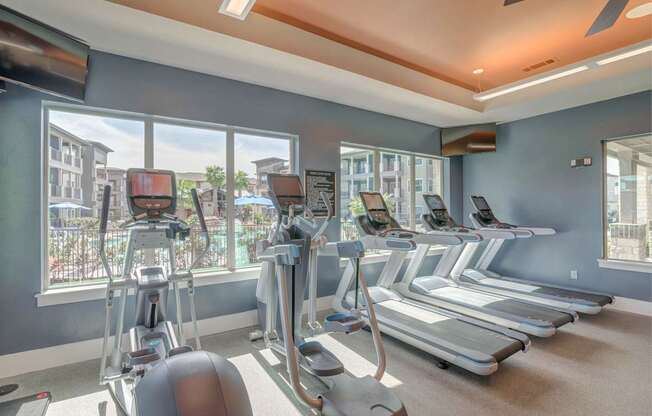 A gym with treadmills, elliptical machines, and a rowing machine.