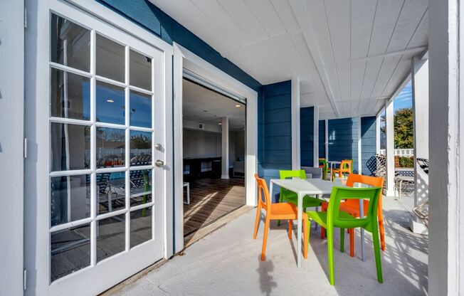 A white door opens to a patio with a table and chairs. at The Beacon, Huntsville, AL, 35816
