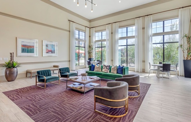 a living room with large windows and a rug and furniture