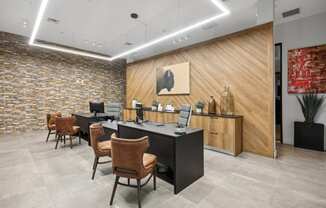 an office with a desk and chairs and a wall with a painting