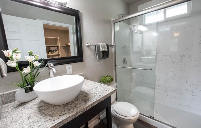 bathroom with granite counters and shower