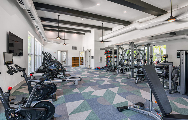 a spacious fitness center with cardio machines and weights