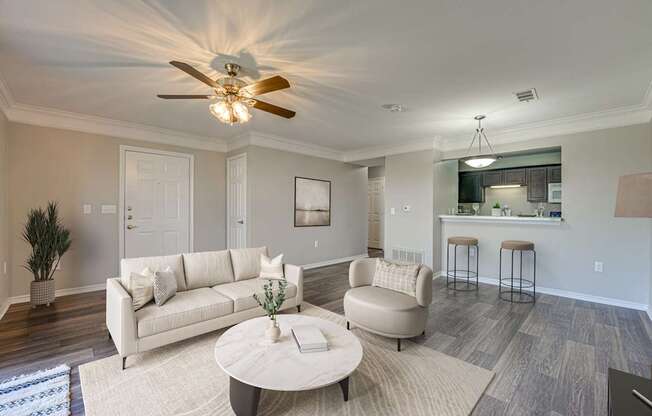 A living room with a white couch and a ceiling fan.