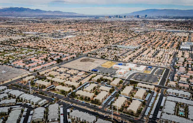 A large, sprawling residential area with a mountain range in the distance.