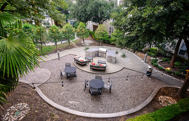 A patio with a table and chairs surrounded by trees.