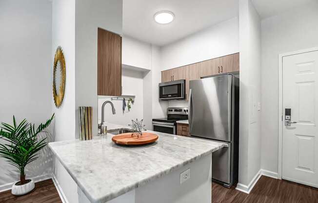 A kitchen with a marble countertop and stainless steel appliances.