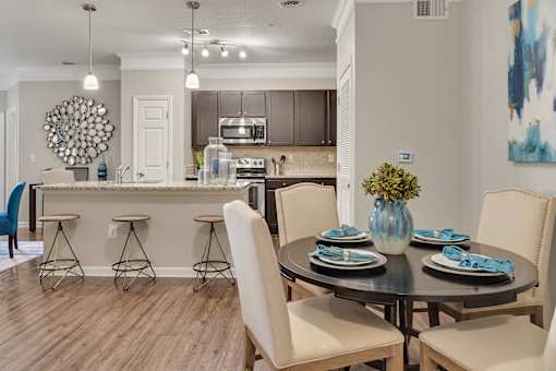 A modern dining room with a round table set for four.