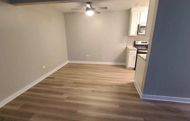 a living room with wood flooring and a ceiling fan