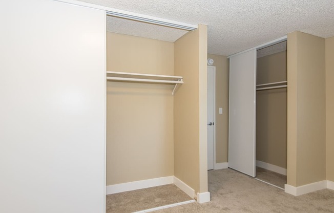 an empty bedroom with a closet and two closets