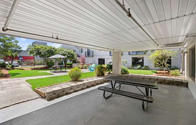 a covered patio with a picnic table and courtyard area in the background at King Arthurs Court, Seattle, 98125