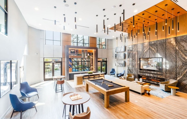 a living room with a fireplace and a pool table at One Ten Apartments, Jersey City , NJ