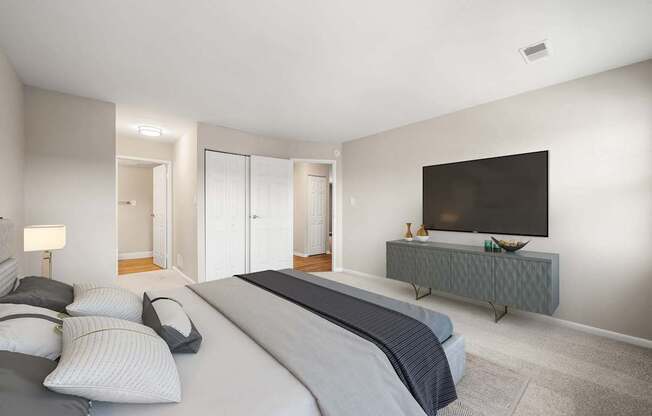 A bedroom with a large bed and a television on a cabinet.