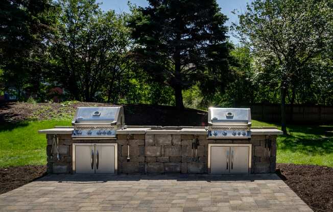 a stone outdoor kitchen with two grills and two stoves