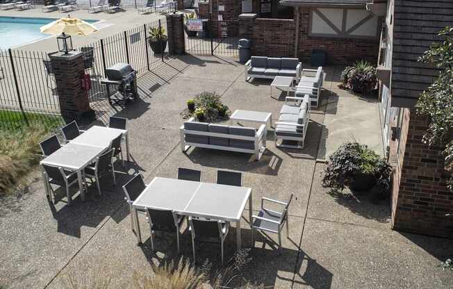 an outdoor patio with tables and chairs and a pool