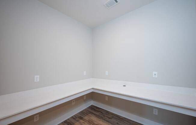 an empty room with a hardwood floor and white walls