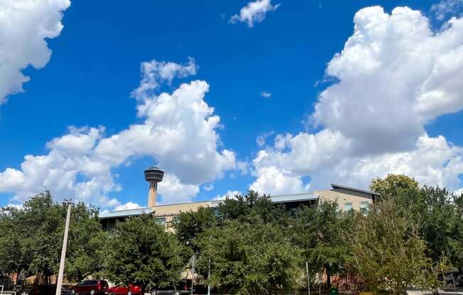 a city with a blue sky with clouds and a building with a tower