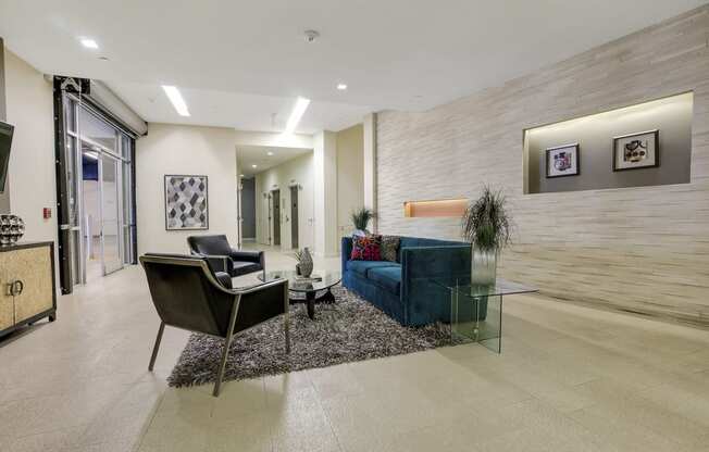 a living room with a couch and chairs and a glass table