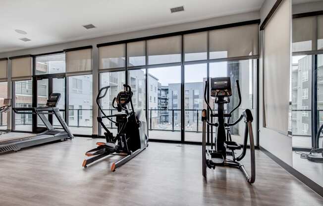 a gym with floor to ceiling windows and exercise equipment