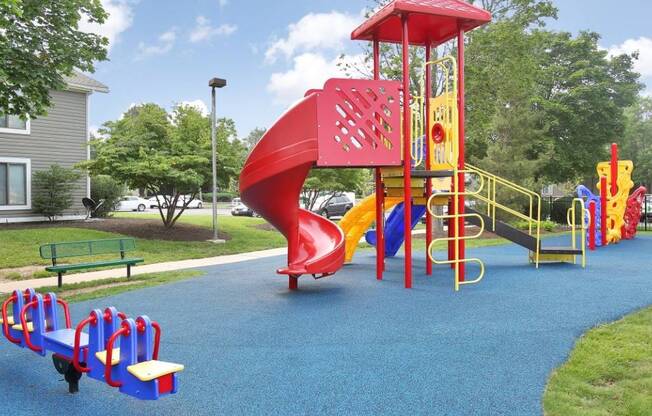 a playground with a red slide in a park