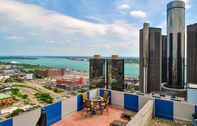 a balcony with a view of the city and a table and chairs