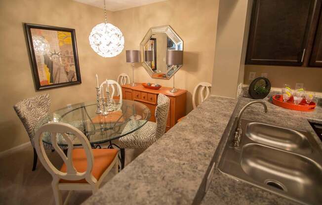 A kitchen with a granite countertop and a glass table.