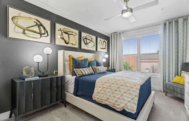 A bedroom with a bed, nightstand, and artwork on the wall.