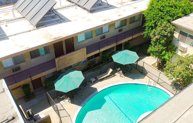 Aerial view of gated community pool with lounging space.