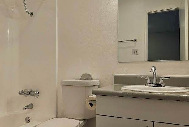 A white toilet in a bathroom with a brown floor.