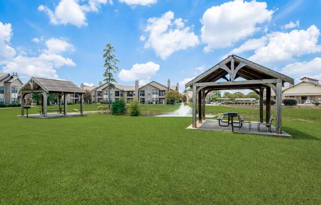 a park with a fountain and benches in the grass