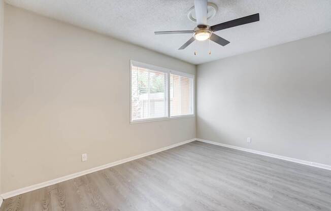 A room with a ceiling fan and a window.