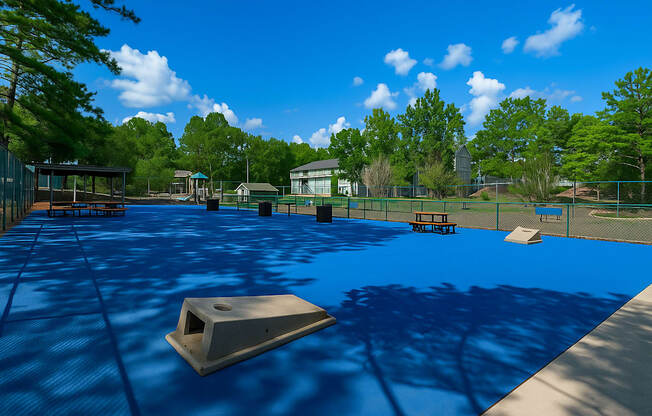 A playground with a blue surface and a slide.