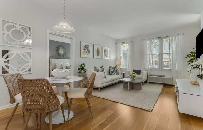 A modern dining room with a white table and chairs.