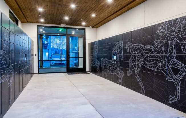 the lobby of a building with a door and a wall with a graphic on it