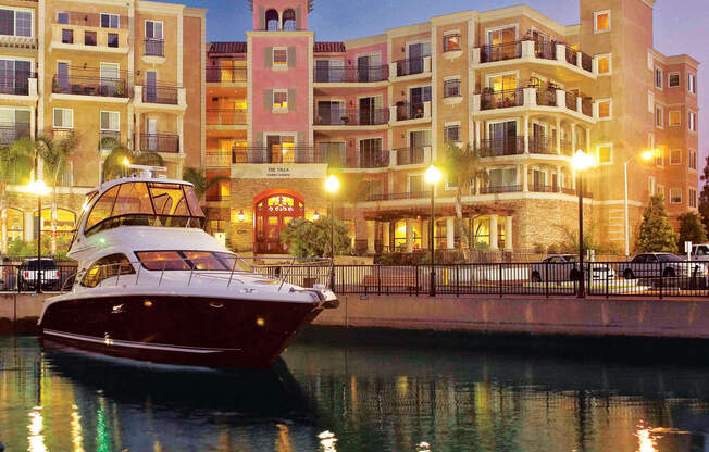 a boat is docked in the water in front of some buildings  at Marina Harbor, Marina del Rey