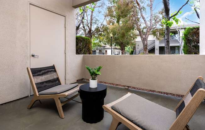 a balcony with two chairs and a table and a door