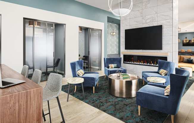 a living room with blue chairs and a table with a laptop