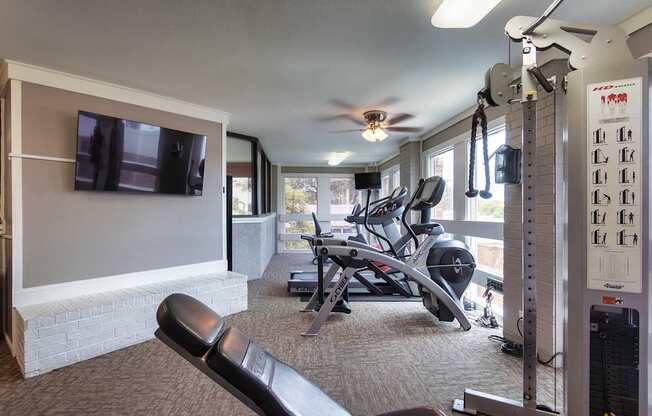 The fitness center with rowing machine, elliptical, treadmill, bike, weight system and free weights at Cambridge Court Apartments in Lake Highlands, Dallas, TX.