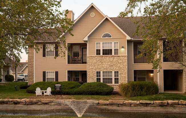 Pond with water fountain and apartments in background