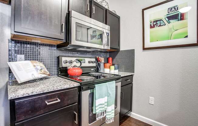 A kitchen with a stove top oven and a microwave above it.