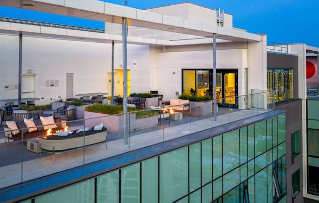A modern house with a glass balcony and a fire pit.