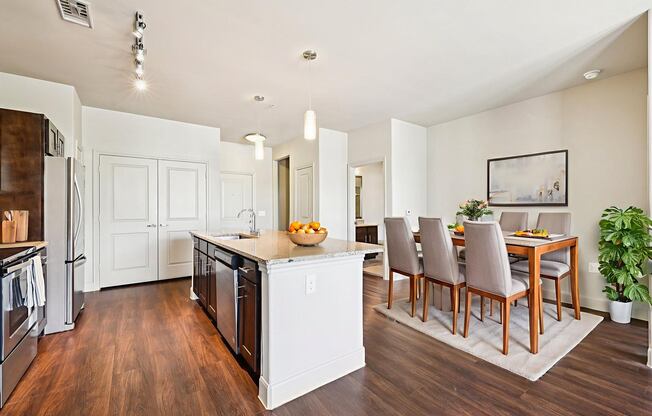 A kitchen with a dining table and chairs.