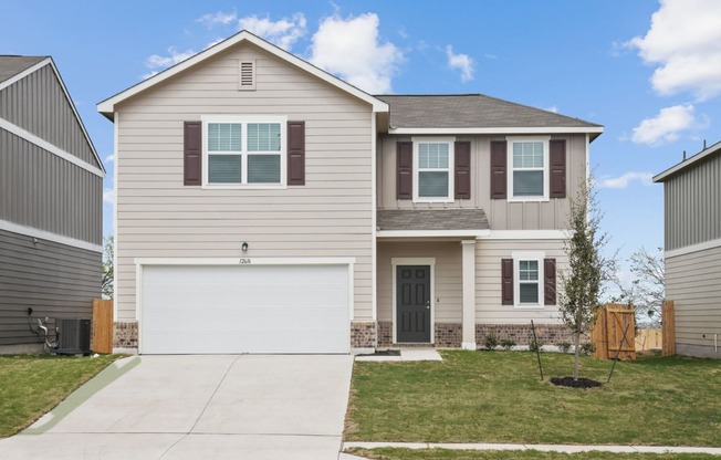 a house with a green lawn and a blue sky in the background at Beacon at Presidential Heights, Manor